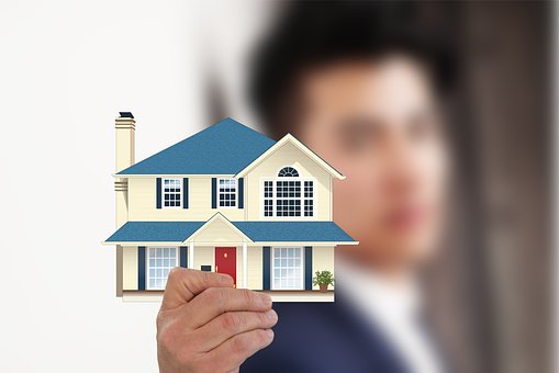 Blurry photo of a man holding a cartoon two story house